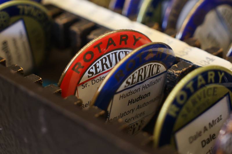 Rotary member buttons sit at a check-in table at a luncheon to celebrate the 110th anniversary of the Rotary Club at Jacob Henry Mansion on Tuesday, Aug. 1 in Joliet.