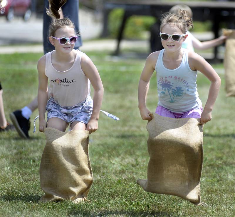 It was sister-verses-sister as Zoey and Piper Sterner compete Saturday, Aug. 6, 2022, in the sack race as part of Kid’s Play Day at the Jordan block in Ottawa.