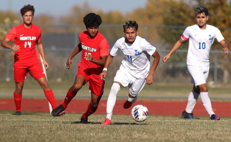 Huntley’s Ansel Dias, center left, races Larkin’s Alexis Sanchez, center right, for the ball in boys soccer regional action at South Elgin on Saturday.