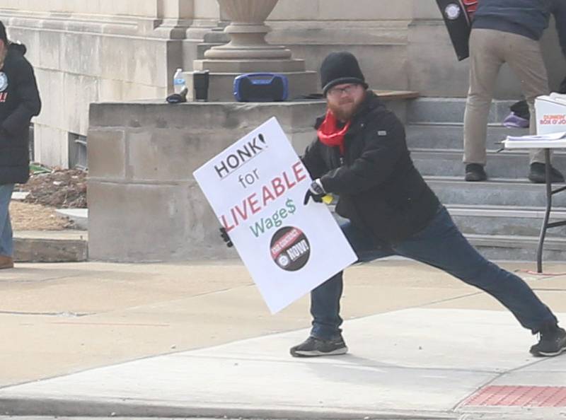 Devin Broderick poses with his "Honk for Liveable Wage$" sign during A “Fight Like Hell” rally held by the National Association of Letter Carriers on Sunday, Feb. 22, 2026 at the United States Post Office in Peru.