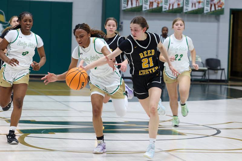 Reed-Custer's Alyssa Wollenzien tips the ball away from Bishop McNamara's Hailey Jackson during Bishop McNamara's 60-36 victory over Reed-Custer in the IHSA Class 2A Bishop McNamara Regional semifinals on Monday, Feb. 16, 2026.