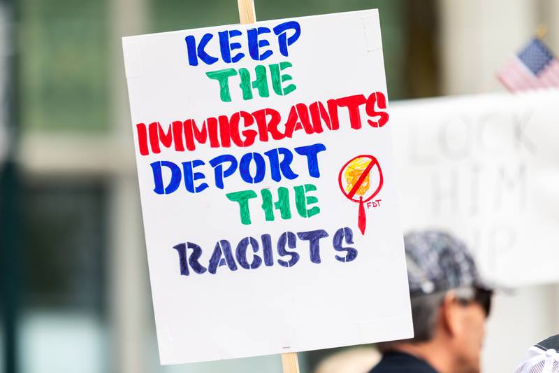 An attendee holds up a sign at the May Day Weekend Rally in Downtown Joliet on May 3, 2025.