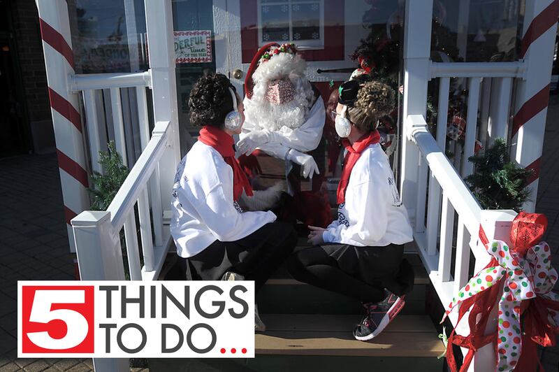 Colleen McSweeney, 13, and Megan Stumo, 13, talk with Santa Claus Saturday afternoon, Nov. 28, 2020, on the front porch the Santa House at the Brink Street Market in downtown Crystal Lake.
