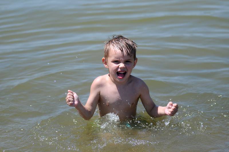 Mikey Broughman. 3, of McHenry, splashes Tuesday, June 14, 2022, in the cool waters of McCullom Lake while at Petersen Park Beach. Temperatures in the McHenry County area reached the mid-90’s.
