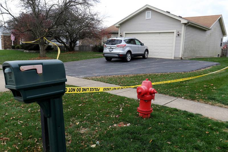 Yellow tape reading "police line do not cross" surrounds the residence at 635 Red Coach Lane on Monday in Algonquin. Two people were found deceased inside the home late Sunday.