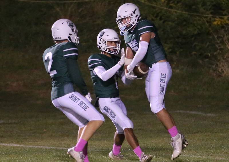 St. Bede's Carson Riva, Jose DeLaTorre, and Halden Heuneburg celebrate after scoring a touchdown against Ottawa on Friday, Oct. 25, 2024 at St. Bede Academy.