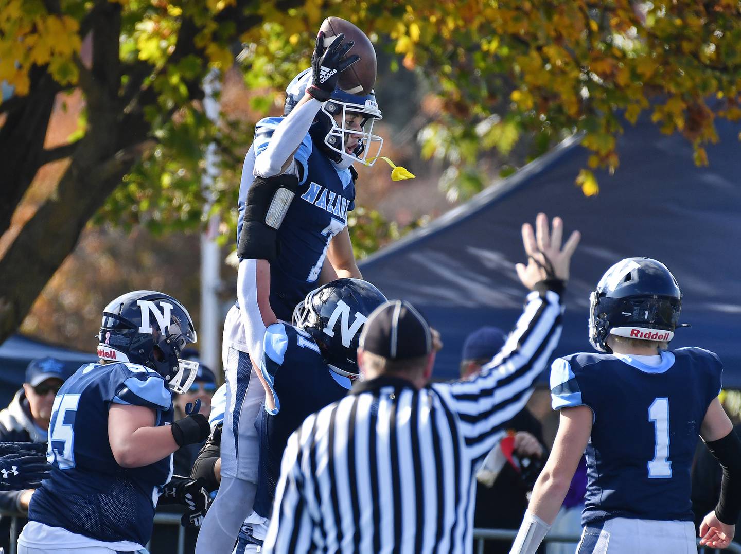 Nazareth's Jake Cestone (top) celebrates with teammates while held aloft by lineman Cullen Craig after making a touchdown catch during a Class 5A second round game against Glenbard South on Nov. 4, 2023 at Nazareth Academy in LaGrange Park.