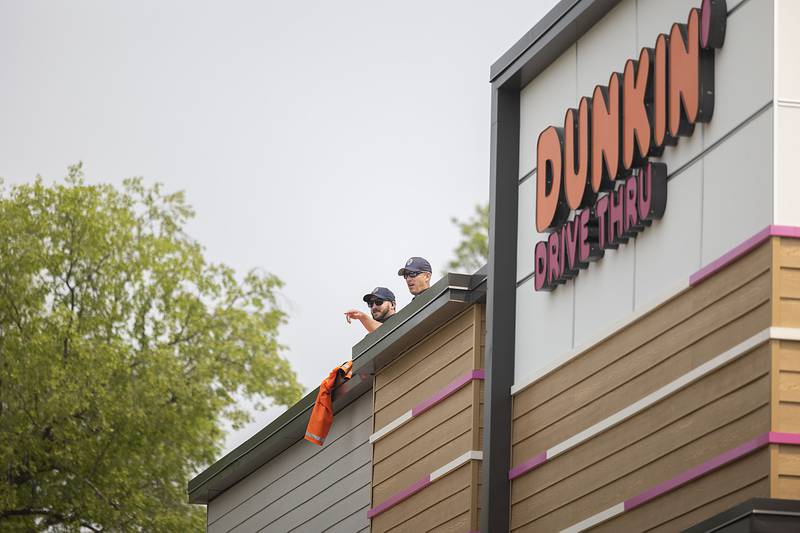 Dixon police’s PJ Ginn (left) and Matt Richards are seen atop the Dixon Dunkin’ Donuts Friday, May 19, 2023 as a fundraiser for Illinois Special Olympics. Donors received a coupon for a free donut. Officers also sold hats, pins and raffle tickets for the fundraiser.