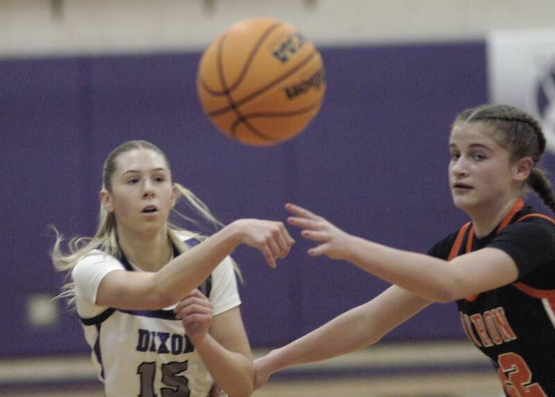 Dixon's Morgan Hargrave passes the ball past Byron's   Aubrie Miller. The Dixon Duchesses hosted Byron in girls basketball Saturday, Jan. 25, 2025.