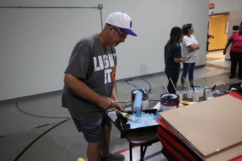 Mark Muszynski, a JJC baking and pastry instructor, refills his paint tray at the Spanish Community Center on Wednesday, Aug. 16, 2023 in Joliet.