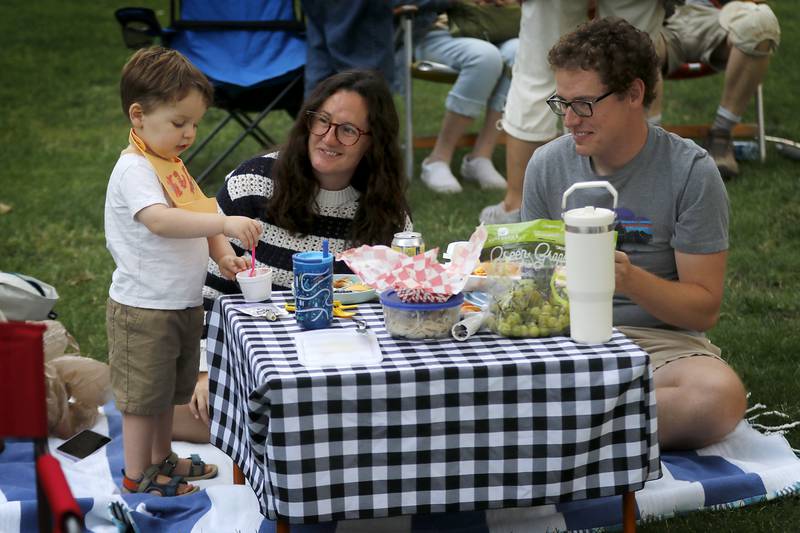 Wyatt Bonde, 2, picnics with his parents, Brittany Malo and Mathew Bonde during a performance of the Woodstock City Band on Wednesday, July 24, 2024, in the historic Woodstock Square.The band that is in its 140th season, performed their Galloping through the Gallery concert for the crowd.