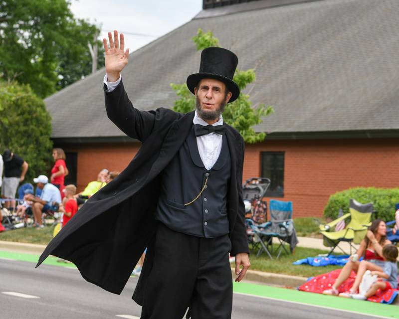 Abraham Lincoln waves to community members during the Independence Day parade on Friday July 4, 2025, held in downtown Downers Grove.