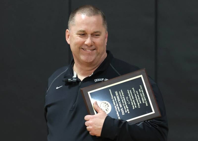 Indian Creek girls basketball head coach Paul Muchmore accepts a plaque Tuesday, Feb. 10, 2026, during a cermony held before Indian Creek took on Rosary. Muchmore, the longtime coach of the Timberwolves, was being honored at his last home game before retirement from coaching at the end of the season.