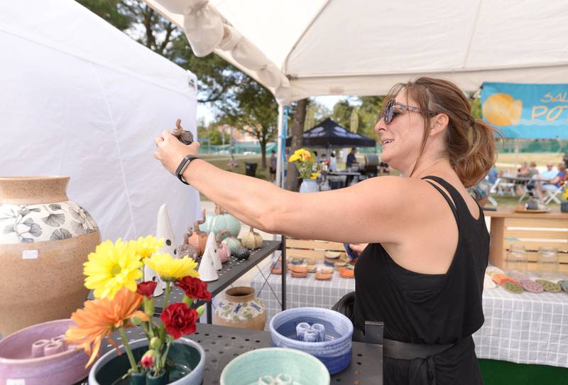 Daniela Milinkovich of Chicago admires one of the pieces made by artist Robert Reckers of Villa Park (not shown) during the West End Arts Festival in LaGrange Saturday, Sept. 21, 2024.