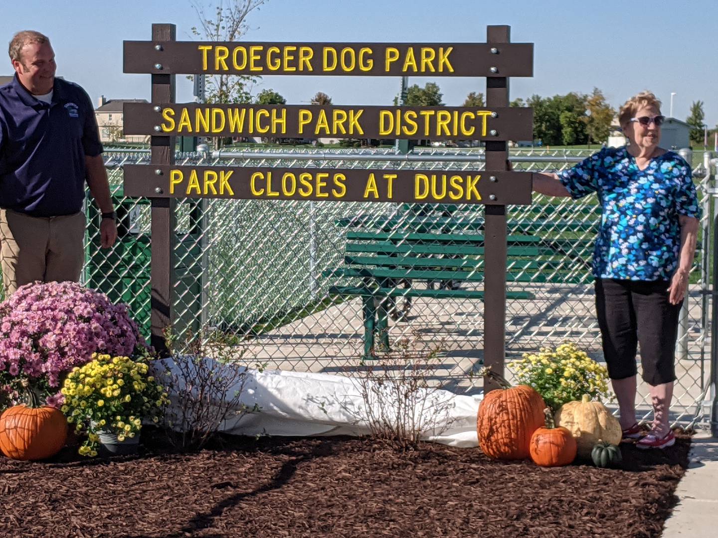 Sandwich Park Board Vice-President Dan Hoyt, left, and Roberta Troeger, right, dedicate the new Troeger Dog Park on Oct. 5. The park is named in honor of Troeger, who had worked for the Sandwich Park District and served on the Sandwich Park Board of Commissioners for a total of 55 years.