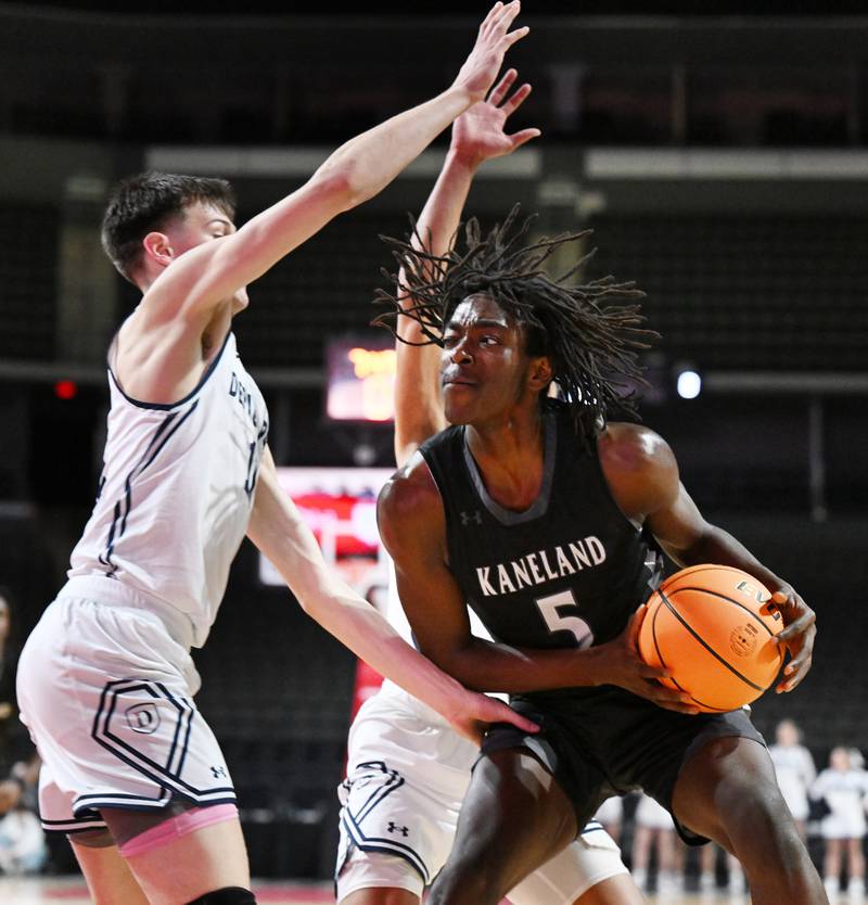 Kaneland's Freddy Hassan, front, looks to make a move toward the basket against DePaul College Prep's Jonas Johnson, left and Makai Kvamme during the Class 3A boys supersectional at NOW Arena on Monday, March 10, 2025 in Hoffman Estates.