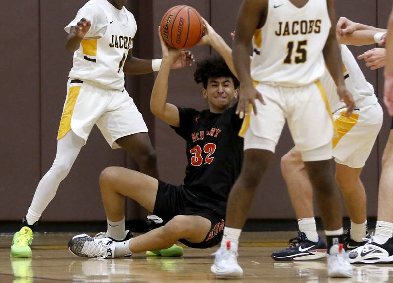 McHenry's Adam Anwar tries to pass the ball as he falls to the court during a Fox Valley Conference basketball game Wednesday, Dec. 7, 2022, between Jacobs and McHenry at Jacobs High School in Algonquin.