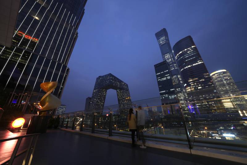 File - People linger in the Central Business District in Beijing, Wednesday, Oct. 26, 2022. If the debt crisis now roiling Washington were eventually to send the United States crashing into recession, the repercussions of a first-ever default on the federal debt would reverberate around the world and quickly. (AP Photo/Ng Han Guan, File)