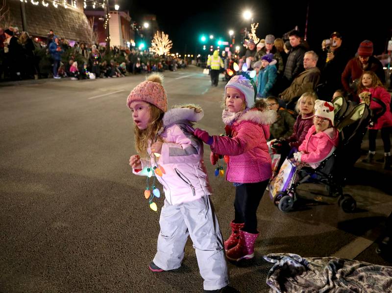 Sophia Schweighardt, 4, and Hannah Wolf, 4, wait for the Wheaton Christmas Parade to begin on Front Street in downtown Wheaton on Friday, Nov. 25, 2022.
