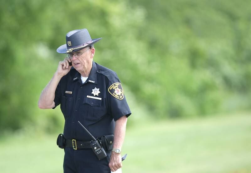 DeKalb County Sheriff Roger Scott talks on his phone after a briefing where he confirmed the body of missing DeKalb man Steven Schulz was found a quarter mile north of the Glidden bridge in the north branch of the Kishwaukee River at 1:08 p.m., Tuesday, July 9, 2014.  Sheriff Scott said pending a coroner's autopsy, which has been scheduled for 10 a.m. today, they are "very certain" the body they found was Schultz.
