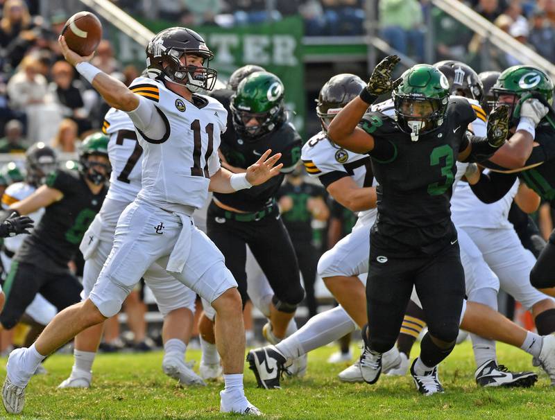 Joliet Catholic quarterback Lucas Simulick (11) fires a pass as Glenbard West’s Jayden Daniel (3) closes in during a game on September 6, 2025 at Glenbard West High School in Glen Ellyn.