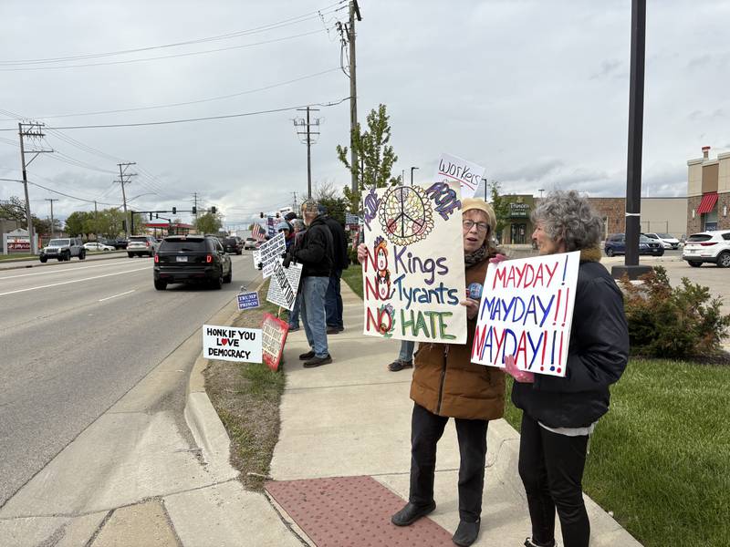 Protestors hold up signs during a May 1 protest in McHenry Friday May 1, 2026.