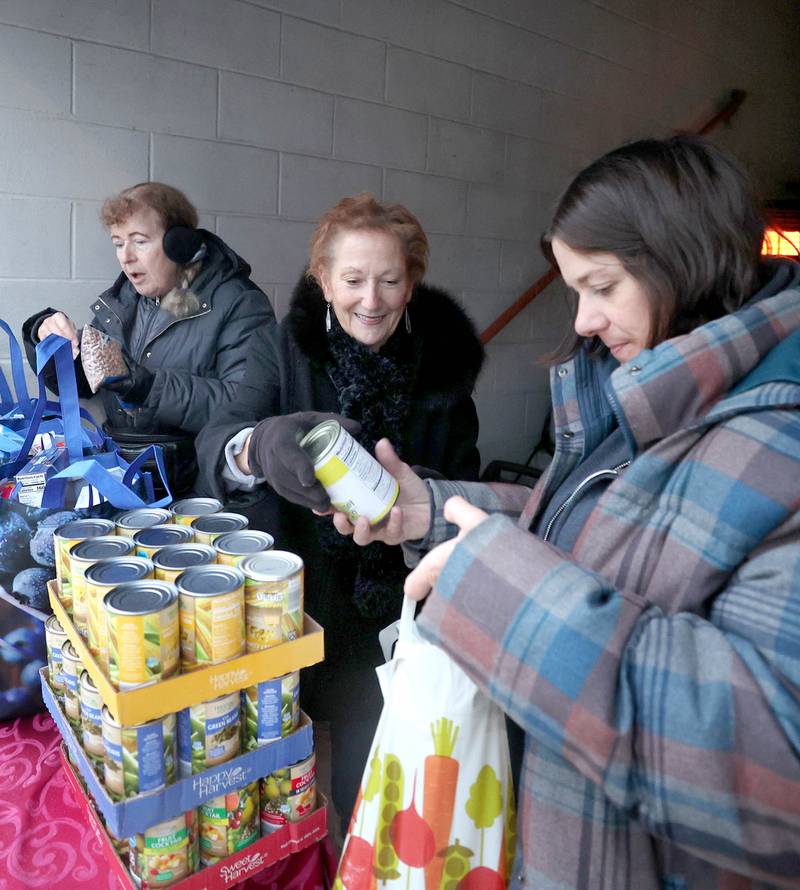 Stage Coach Players Outreach Committee members Deb Brubaker, (left) Jan Kuntz and Angela Schiola (right) sort donations and pack bags Tuesday, Nov. 15, 2022, while collecting donations at the theater in DeKalb for their Thanksgiving food drive. The group is working with the Salvation Army to put together Thanksgiving meals for local families in need.