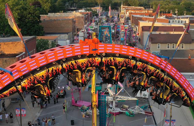 Kids hang upside down while riding the Fireball carnival ride during Spring Valley Summerfest on Thursday, June 19, 2025 downtown Spring Valley. The festival features a carnival, live entertainment, food vendors and fireworks on Saturday at dusk.