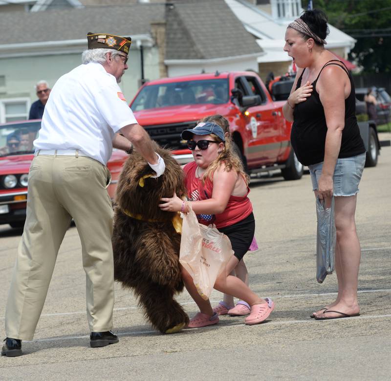 Veteran Ken Williams gives a very large teddy bear to Taytum Coulter, 10, of Oregon, as the Oregon VFW/American Legion float passes by her family during the Let Freedom Ring parade on Friday, July 4, 2025 in Mt. Morris. Taytum's grandfather, Robert, is a member of Oregon VFW OPost 8739 and was driving the truck that was pulling the float. Taytum was excited to receive the bear stating: "I didn't know it was on the float".