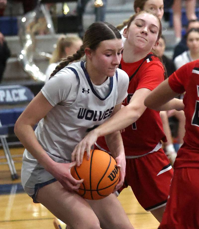 Oswego East's Aubrey Lamberti (left) and Yorkville's Annabel West fight for possession during their game Tuesday, Feb. 11, 2025, at Oswego East High School.