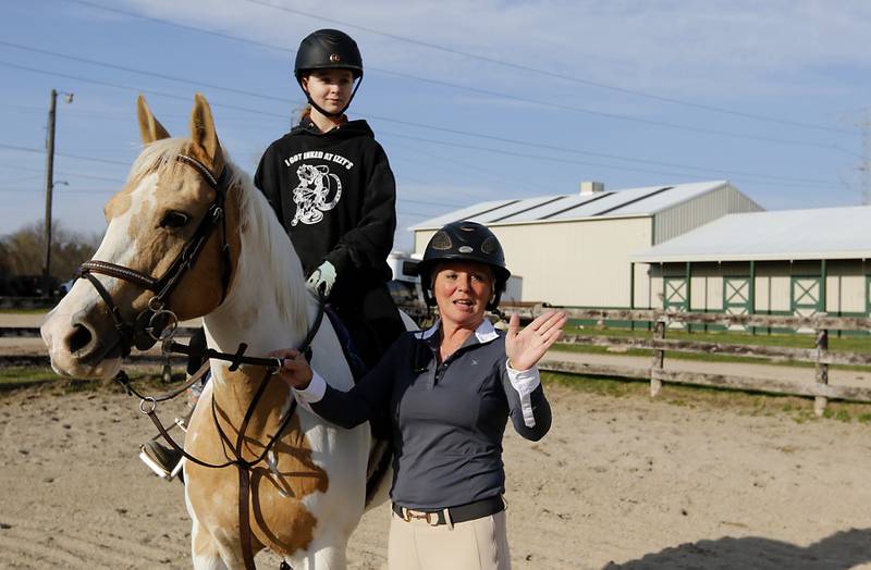 Teacher Amber Bauman works with Violet Capra and Capra's horse, Angel, on Wednesday, April 16, 2025, during a horseback riding lesson at Valley View Acres near Woodstock. Bauman, also teaches 6th grade math at Hannah Beardsley Middle School in Crystal Lake.
