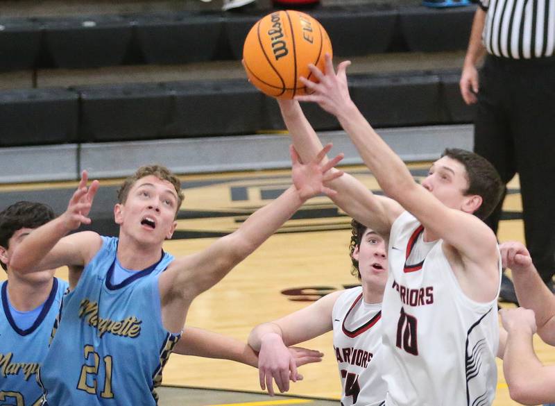 Woodland's Jaron Follmer grabs a rebound over Marquette's Lucas Craig during the Tri-County Conference Tournament on Tuesday, Jan. 28. 2025 at Putnam County High School.