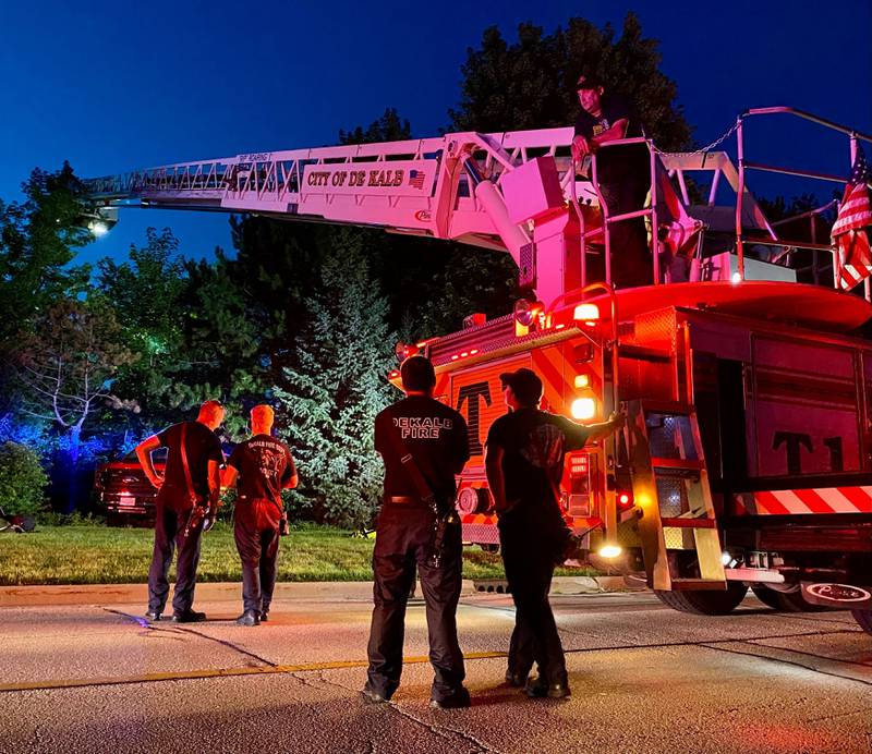 DeKalb firefighters are hoisted into the air on a ladder truck to help provide light to emergency divers undertaking a water rescue on Sunday, July 27, 2025, in the 600 block of Ridge Drive in DeKalb.