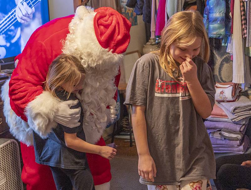 Kinsley, 7, and Payton, 9, greet Santa Monday, Dec. 22, 2025, after accepting a delivery from him and the Rock Falls Police Department.