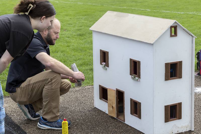 Leah Stach, a junior at Dixon High School, works with teacher Ryan Deets on where to set her team’s model house on fire Tuesday, April 22, 2025.
