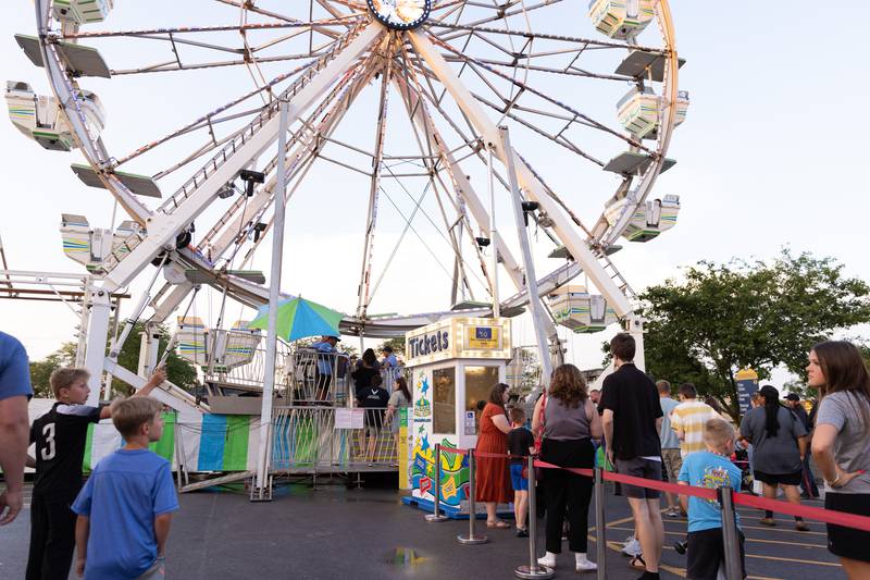 Festivalgoers stand in line for 50-cent ferris wheel tickets, a Thursday-only special to commemorate the 50th Anniversary of the Bourbonnais Friendship Festival on Thursday, June 26, 2025.