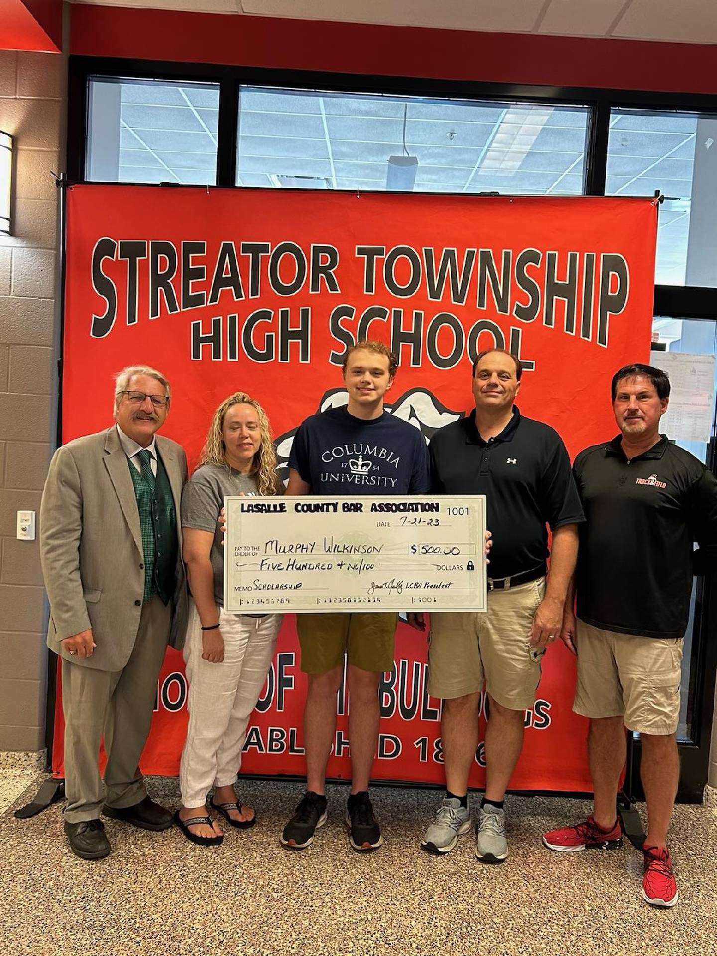 Murphy Wilkinson (center), flanked by his parents Nellie and Matt receives a $500 scholarship dated July 21, 2023, from the La Salle County Bar Association at Streator Township High School. At right 
is social science mentor Rob Tyne and to the left is La Salle County Bar President Jim Reilly.