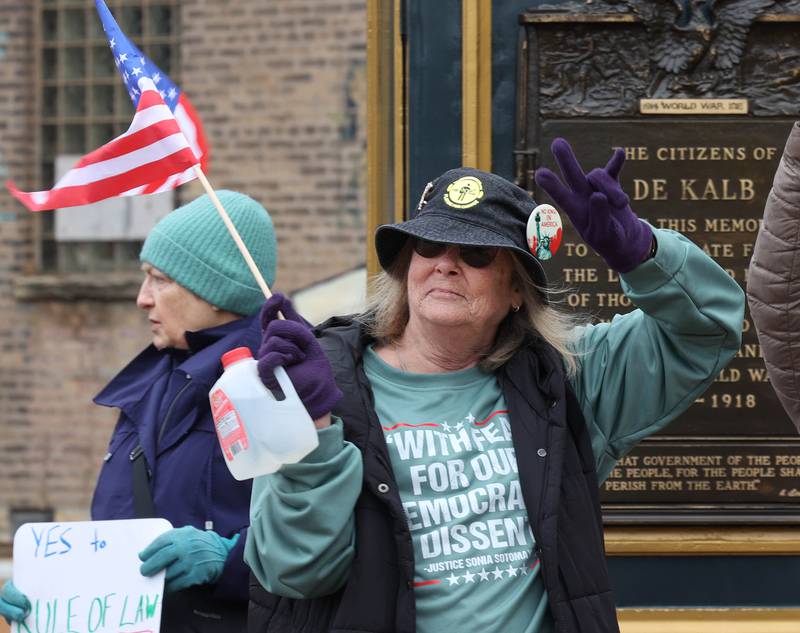 Protesters held signs and waved flags Tuesday, Jan. 6, 2026, during a Venezuela Rapid Response Rally at Memorial Park on the corner of First Street and Lincoln Highway in DeKalb. The group gathered to voice their opposition to President Donald Trump and the administrations recent actions in Venezuela.