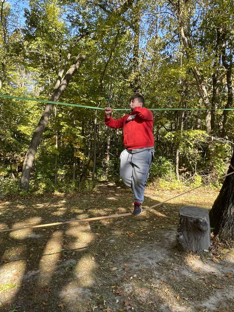 Isaac Diveley attempts to cross the ropes and practice his balancing skills at Echo Bluffs.