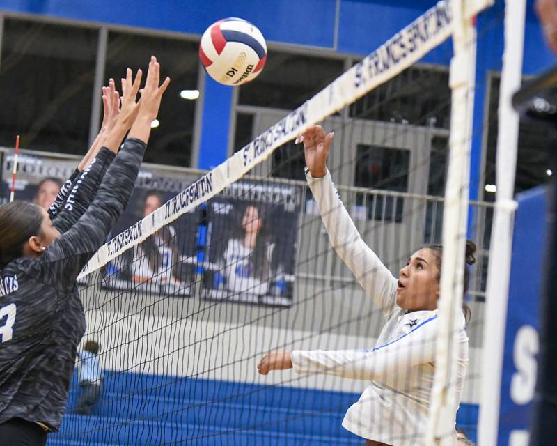St. Charles North's Sidney Wright, right spikes the ball pass St. Francis defenders on Wednesday Oct. 2, 2024, during the first game of two held at St. Francis High School in Wheaton.