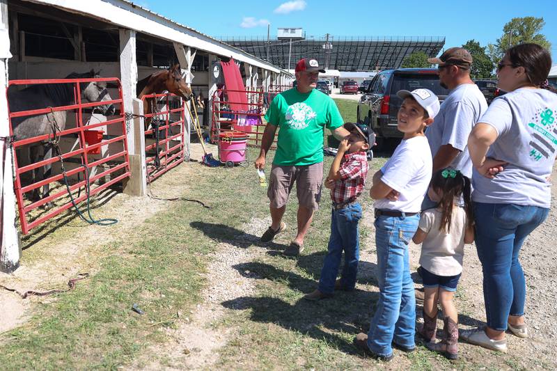 Doug Binns, of Blue Winds Farm, gives a family a tour of his award winning horses at the Grundy County 4-H Fair on Sunday, July 30 in Morris.