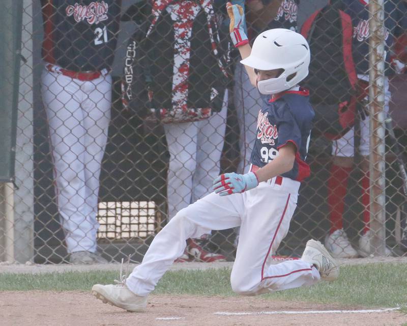 Streator All Stars Bradley Matsko slides safely into home plate after scoring a run against Ottawa American during the District 20 championship game on Sunday, July 14, 2024 at Washington Park in Peru.