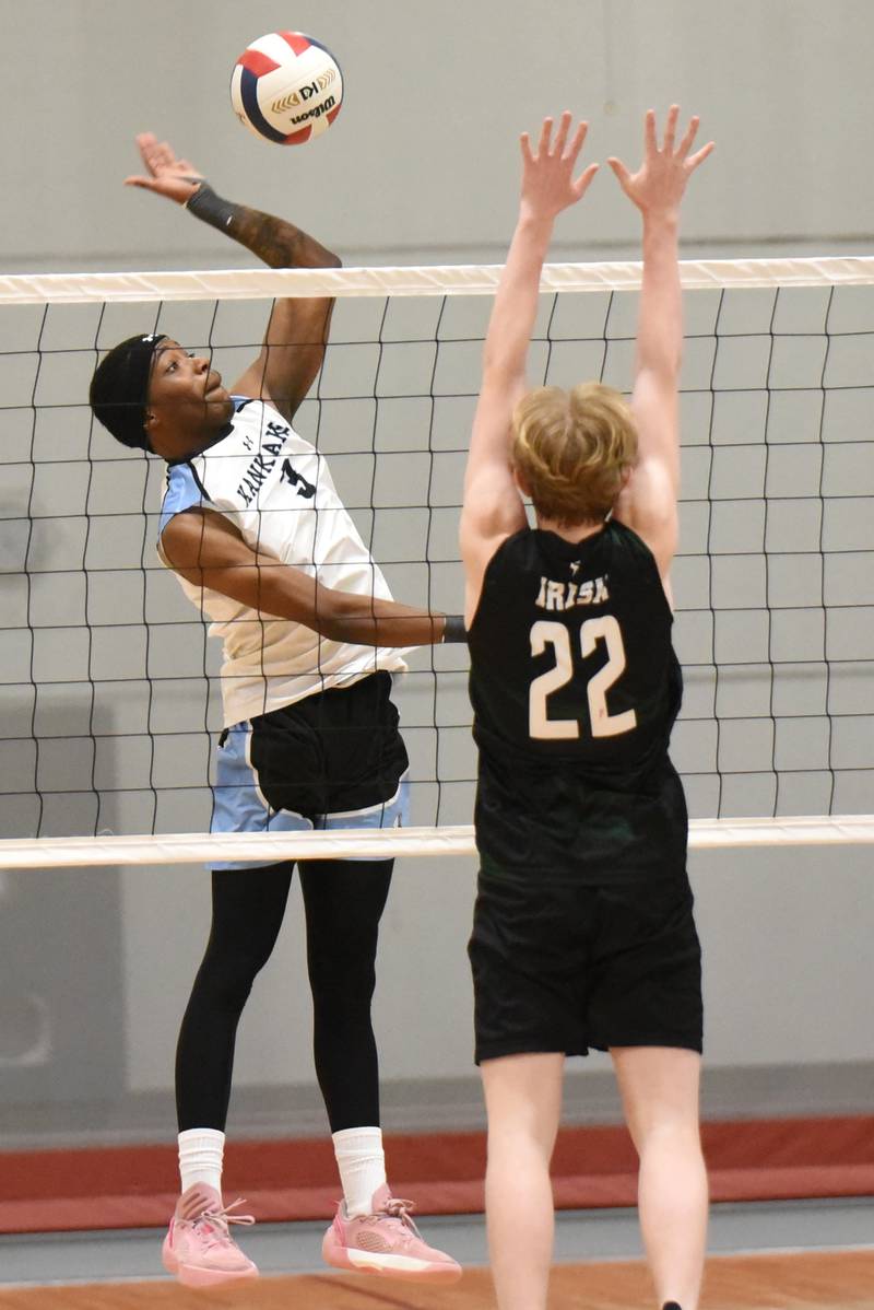 Kankakee's Jamon Barlow, left, looks to send a hit past Bishop McNamara's Cooper Austiff during a game at Kankakee Tuesday, March 31, 2026.