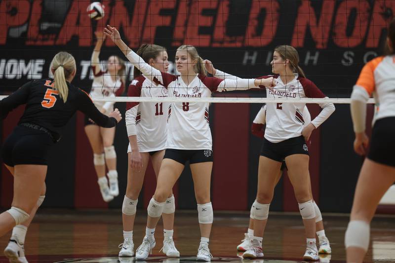 Plainfield North’s Lauren Jansen (11), Sydney Pavlik (8) and Christina Petkus (2) wait as Ella Strausberger serves against Plainfield East on Thursday night.