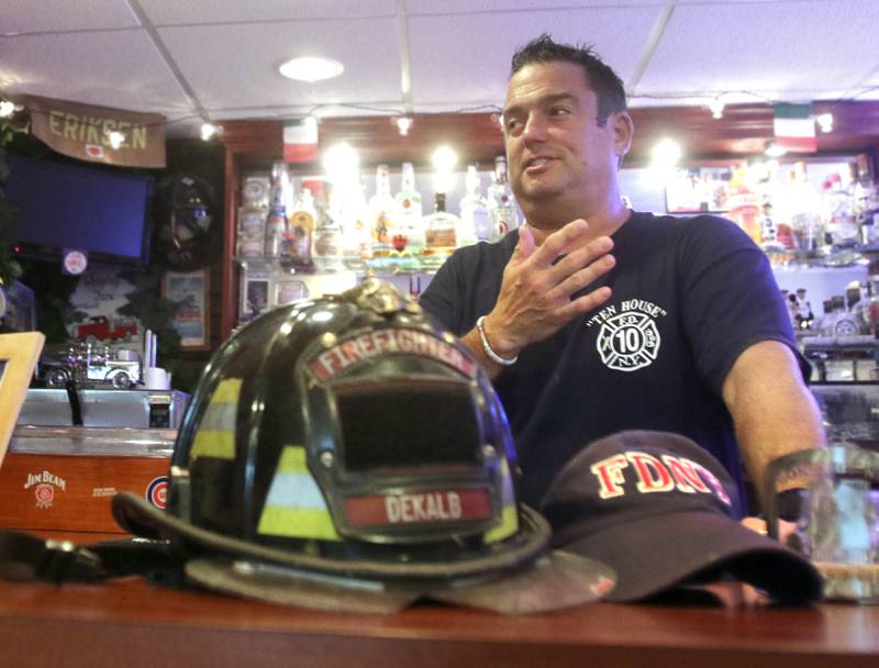 DeKalb firefighter/paramedic Pat Eriksen, surrounded by firefighter memorabilia from his family, talks Monday, Aug. 30, 2021, in his Sugar Grove home, about his cousin John Joseph Florio, a New York City firefighter from Engine Company 214 out of Brooklyn, who was killed while responding to the Twin Towers during the Sept. 11, 2001 terrorist attacks. This year marks the 20th anniversary of the tragedy.