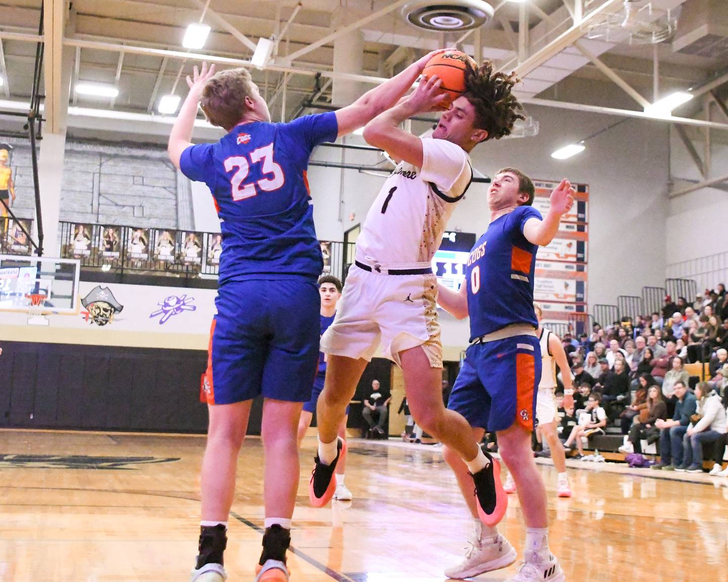 Genoa-Kingston's Hayden Hodgson (23) gets a hand on the ball as Sycamore's Josiah Mitchell (1) tries to take a shot that was ruled a jump ball during the game on Wednesday Feb. 19, 2025, held at Sycamore High School.