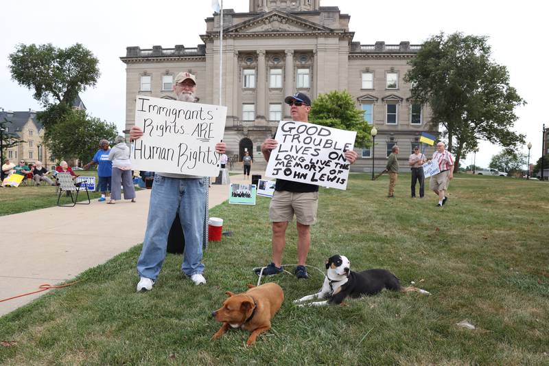 during a "Good Trouble Lives On" rally held in Kankakee as part of a national day of peaceful protests on Thursday, July 17, 2025.Bill Drury, right, of Bourbonnais, and his two dogs, Roxy and Amber, stand with David Schilling, of Bradley, holding signs during a "Good Trouble Lives On" rally held in Kankakee as part of a national day of peaceful protests on Thursday, July 17, 2025.