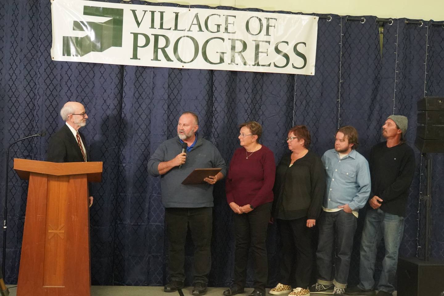 The Herrmann family received the Robert Stouffer Special Recognition award at the Village of Progress Annual Banquet on Wednesday, Oct. 22, 2025 in Oregon. At left is Master of Ceremonies Tom Wadsworth.