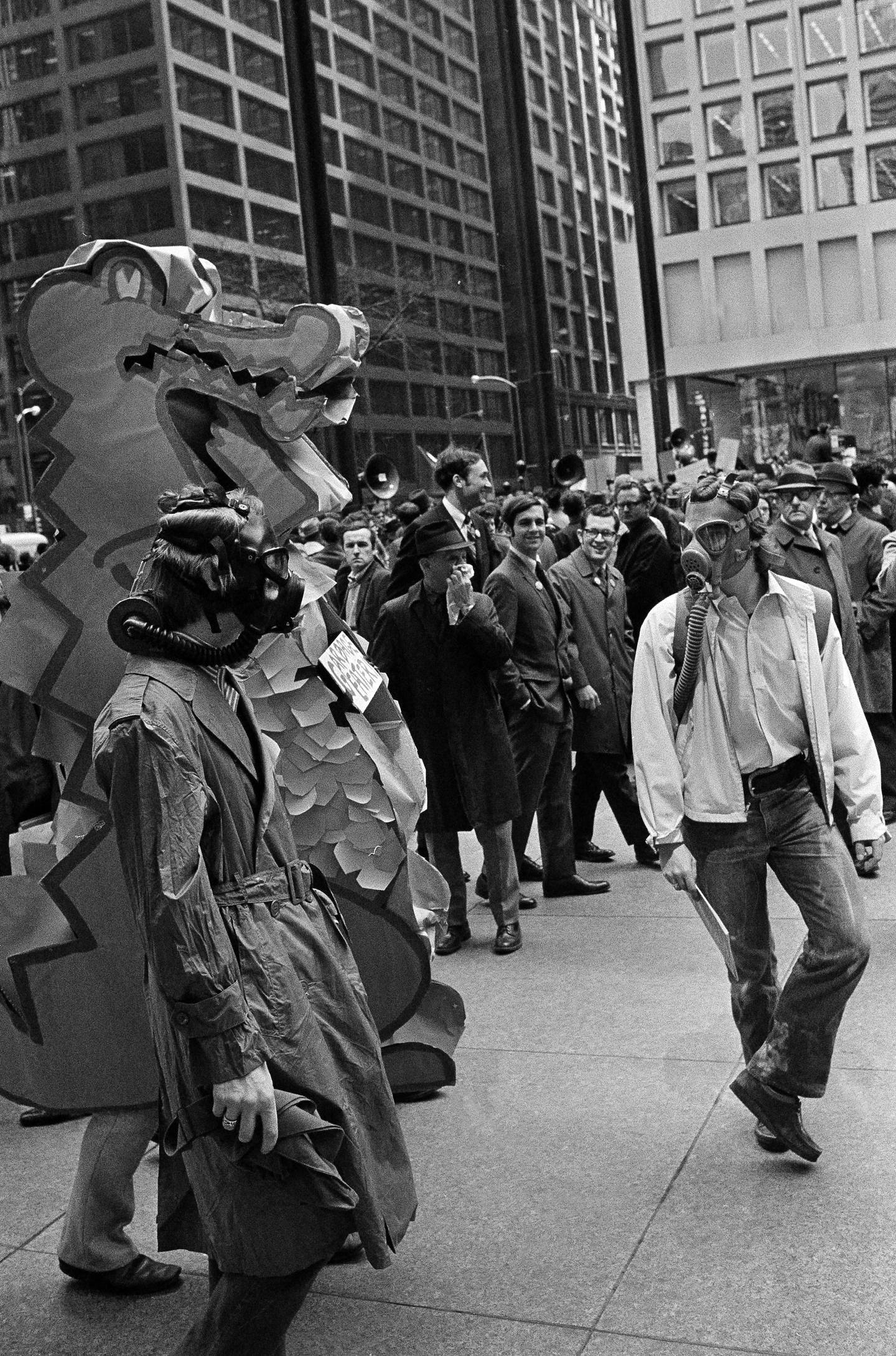 Gas-masked marchers and a dragon labeled "garbage eater" arrive in Chicago's Civic Center Plaza for the first observance of Earth Day, April 22, 1970.