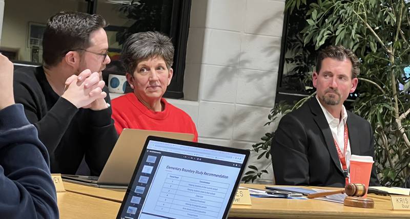 On Feb. 14, 2023, Sycamore Community School District 427 Board of Education member, Eric Jones, left, talks with Superintendent Steve Wilder, right about Wilder's proposed changes to the district's elementary school boundaries for the 2023/2024 academic year. Board member Kris Wren, middle, looks on during the discussion.